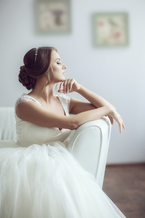 Portrait of a bride on a white sofa in a bright roomの写真素材