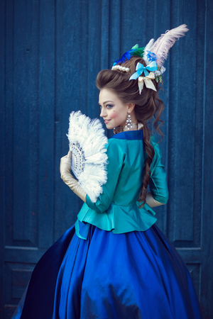 Beautiful caucasian girl dressed in the style of the Renaissance. Photo in blue tones