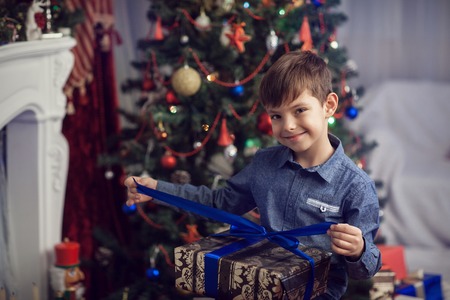 The boy at the New Years Eve opens a giftの写真素材