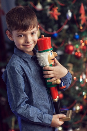 A boy at a New Year tree with a nutcracker
