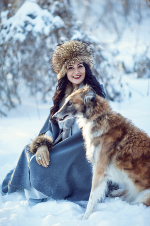 A girl with greyhounds on the snowの写真素材