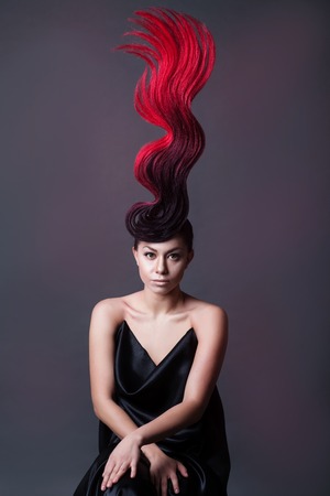 studio portrait of a woman with a fantasy fiery hairdoの写真素材