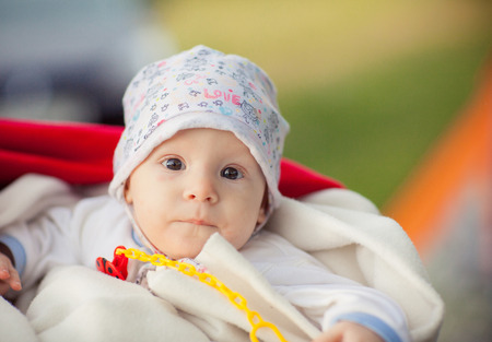 Portrait Contented baby in a cap on the street