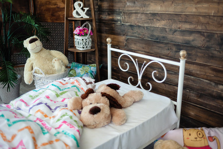 white bed forged wrought iron. Bed is covered with white linens. In the frame of soft toysの写真素材