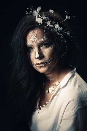 A girl with a stylized make-up of a dead bride. Long-haired brunette in a white shirt