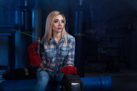 Girl with a welding machine. girl in a blue shirt