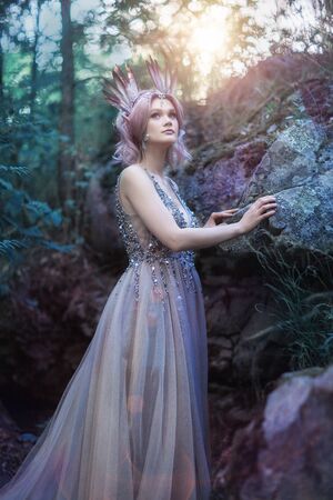 Fairytale girl in beautiful stones. Stones in the moss.の写真素材
