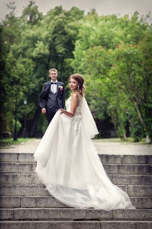 The bride and groom on the steps of the stairs. Newlywedsの写真素材