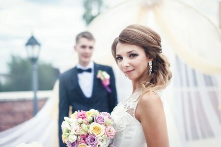 Portrait of a young bride and groom with a bouquet of flowersの写真素材