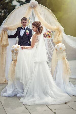 Portrait of a young bride and groom with a bouquet of flowersの写真素材