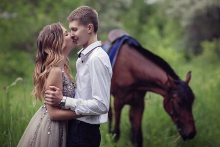 Love story. Two lovers in the forest. Photo with a bay horse.の写真素材
