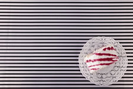 White pastries with pink cream on a striped background.の写真素材