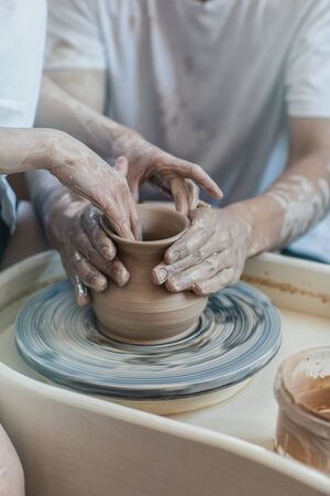Two young people make a vase from clayの写真素材