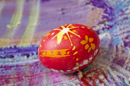 Single easter egg with beautiful  color abstract pattern, isolated on colored textured background.の写真素材