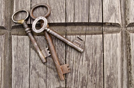 Vintage keys on old wooden background. Close-up. Three old, rustic keys on the table.の写真素材