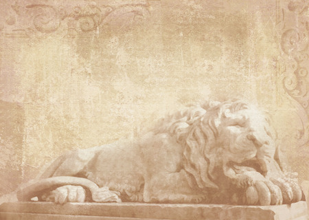 Sculpture of sleeping lion on grunge background with carved architectural details on stone as decoration on a facade building. Statue of lion in Lviv, Ukraine.の写真素材