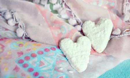 Cookies in the shape of hearts on the textiles background. Boho style. Love concept background. February 14 Holidays. Happy valentines day celebration.の写真素材