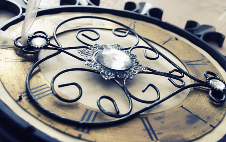 Old vintage wall clock with roman numbers and ornamental metal author design heart instead of...