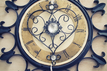 Old vintage wall clock with roman numbers and ornamental metal author design heart instead of clockwise. Abstract composition for your design.の写真素材