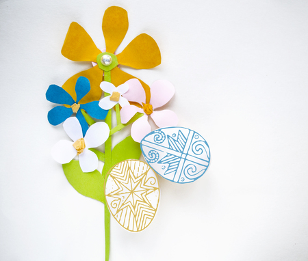 Colorful Easter composition with eggs and flowers on a white background. Paper cut, application style. Easter holiday card, poster, banner.の写真素材