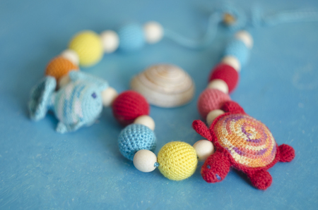 Necklace made from knitted beads and toys for the baby sitting in a sling. Knitted beads. Sling necklace.の写真素材