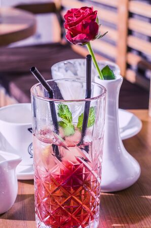 Photo mojito from strawberries. Red rose in a white vase in the background.の写真素材