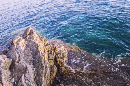 Turquoise shallow water surface and rocks stones on sea floor. Shallow transparent green sea water rocks at the bottomの写真素材