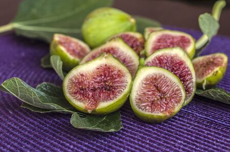 Fresh sliced figs on a green leaves. Tropical fruit. Top viev.