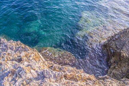 Turquoise shallow water surface and rocks stones on sea floor. Shallow transparent green sea water...