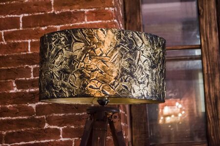 Handmade table lamp with bronze floor lamp. Lighting in a cozy interior. Texture paste and bronze paint for decoration.の写真素材