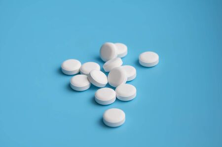 whte pills or tablets for virus on blue background