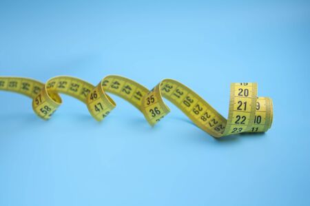 Yellow centimeter tape on blue background