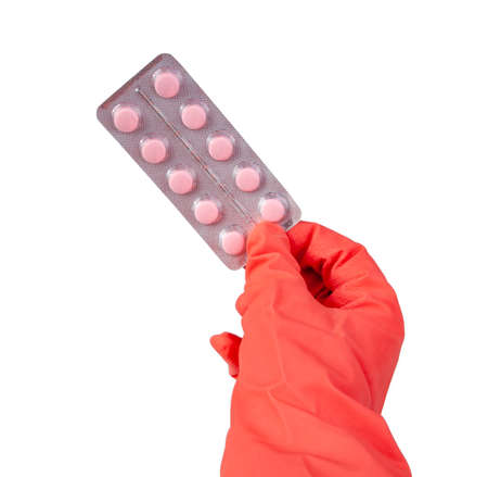 Pink pills medical in rubber glove hand isolated on the white