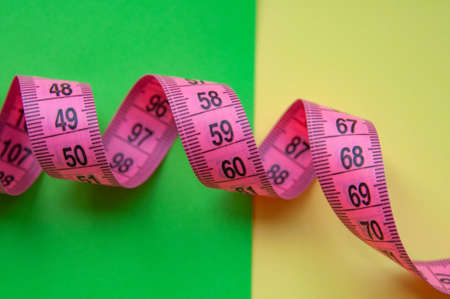 Pink centimeter measure tape on colorful backgroundの写真素材