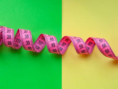 Pink centimeter measure tape on colorful backgroundの写真素材