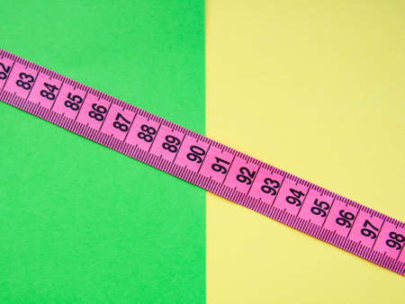 Pink centimeter measure tape on colorful backgroundの写真素材