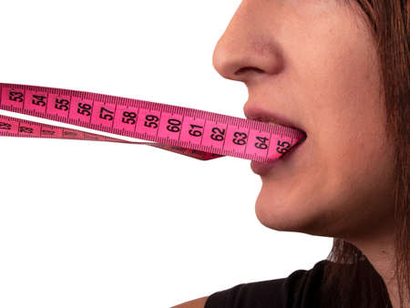 Girl face and tape measure in mouth isolated on the white