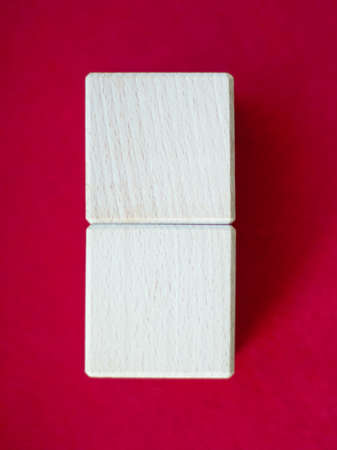 Wooden block on red background with space for textの写真素材