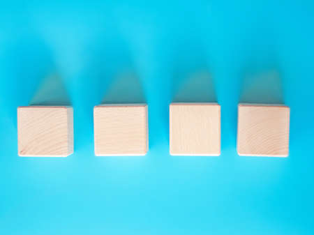 Wooden cube on blue background with space for textの写真素材