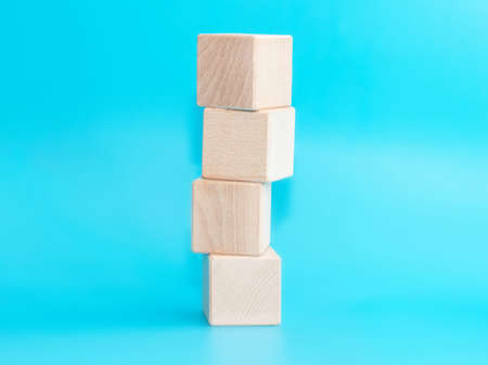 Wooden cube on blue background with space for text