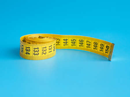 Yellow centimeter tape measure on blue backgroundの写真素材