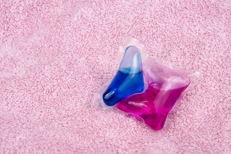 Colorful gel capsule for washing on pink material soft backgroundの写真素材