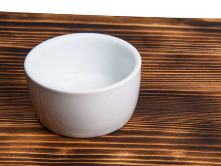Empty white dish on dark wooden deskの写真素材