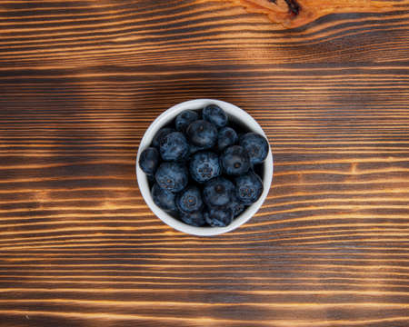 Fresh blueberry in white dish on wooden backgroundの写真素材