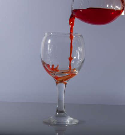 red wine splash in glass on white background