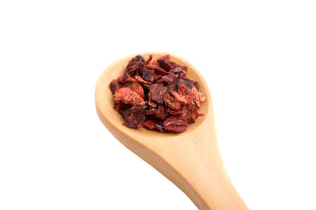 red paprika dried pepper in wooden spoon isolated on the whiteの写真素材