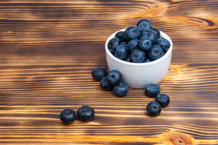 Fresh blueberry in white dish on wooden background copyspaceの写真素材