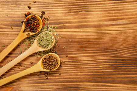 Three wooden spoon with different dry spices on natural wooden backgroundの写真素材