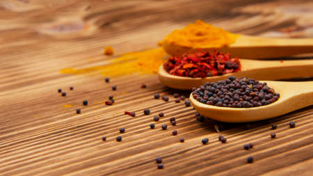 Dry different spices in spoons on wooden backgroundの写真素材