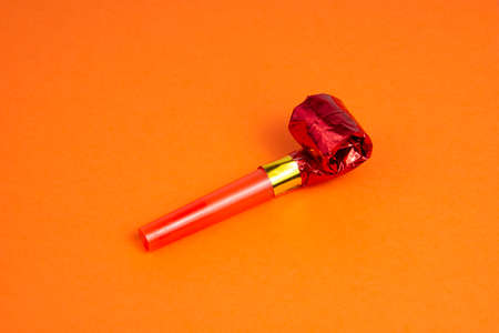 Party foil red horn noisemaker for carnival on the orange backgroundの写真素材